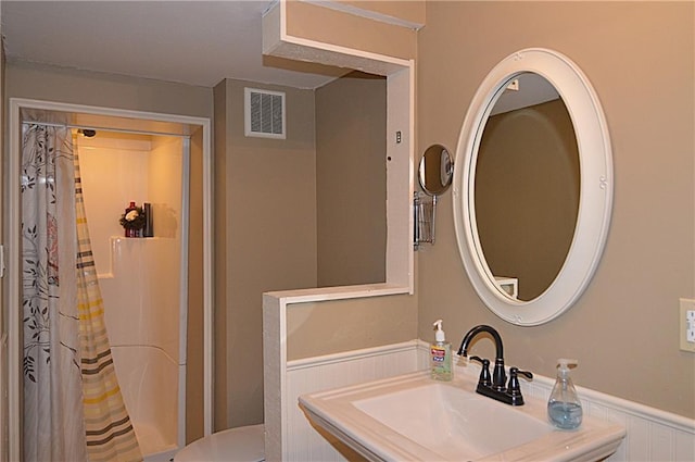 bathroom with toilet, sink, and a shower with curtain