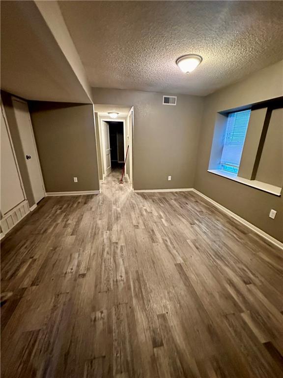 interior space featuring wood-type flooring and a textured ceiling