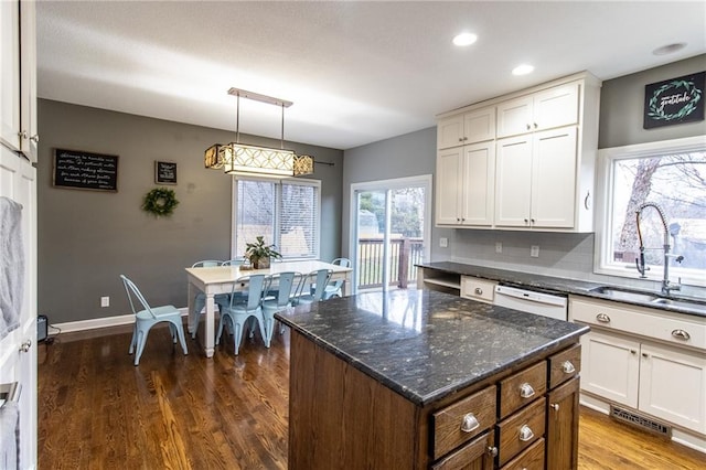 kitchen with white cabinets, a kitchen island, and sink