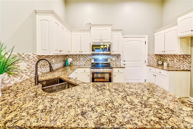 kitchen featuring backsplash, sink, white cabinets, and stainless steel appliances