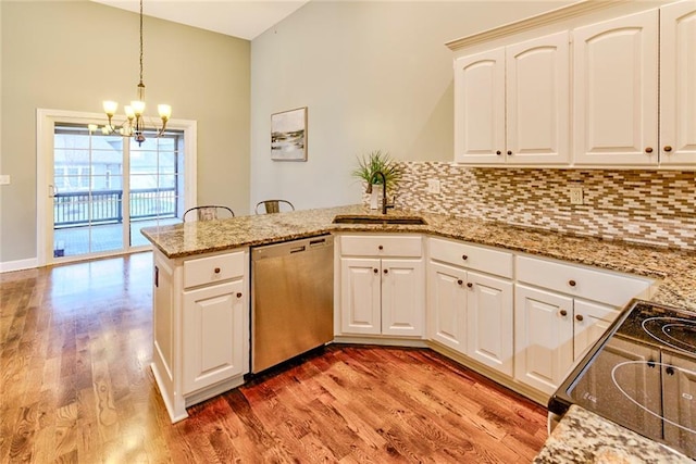 kitchen with range, kitchen peninsula, sink, stainless steel dishwasher, and white cabinetry