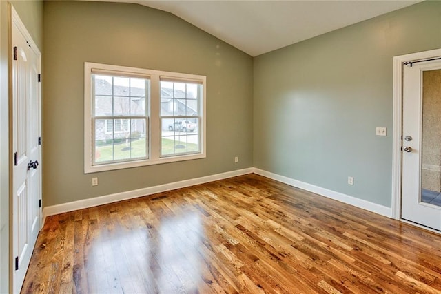 unfurnished room with light hardwood / wood-style flooring and lofted ceiling