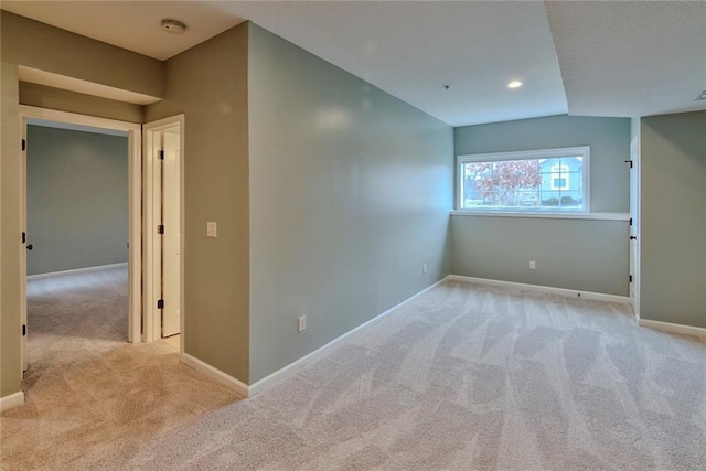 empty room with lofted ceiling and light carpet