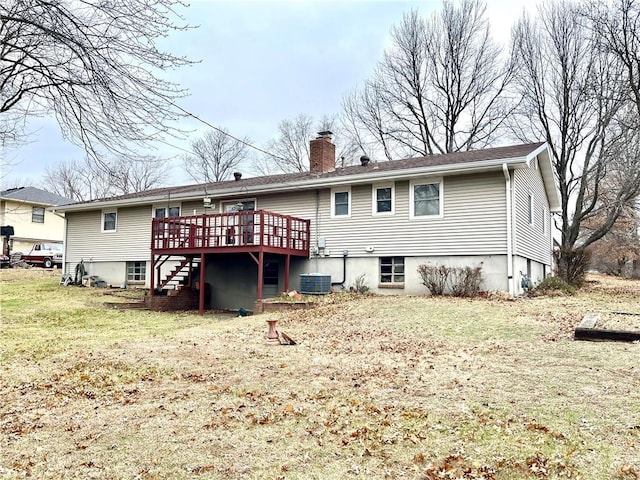 rear view of property with central AC unit, a yard, and a wooden deck