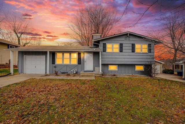 split level home featuring a garage and a yard