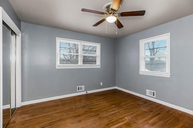 unfurnished bedroom featuring ceiling fan, dark hardwood / wood-style floors, and a closet