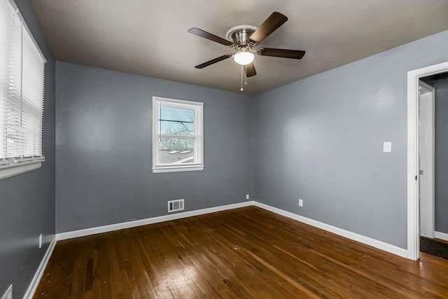 empty room with ceiling fan and dark hardwood / wood-style floors