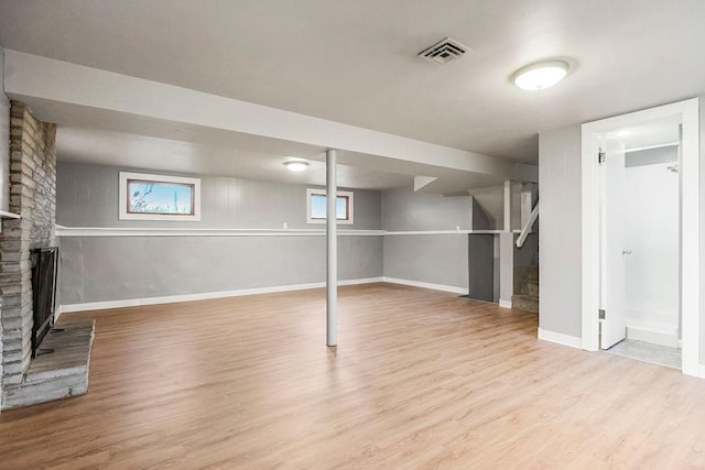 basement featuring a fireplace and light wood-type flooring