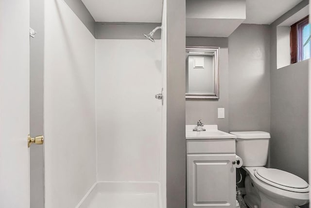 bathroom featuring vanity, toilet, and a shower