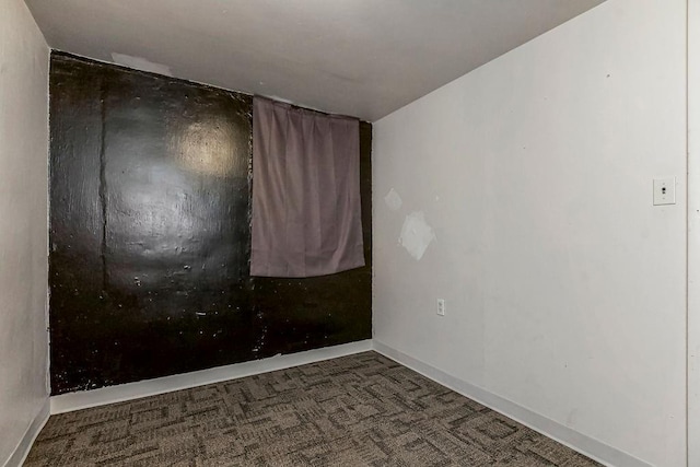 empty room featuring dark carpet