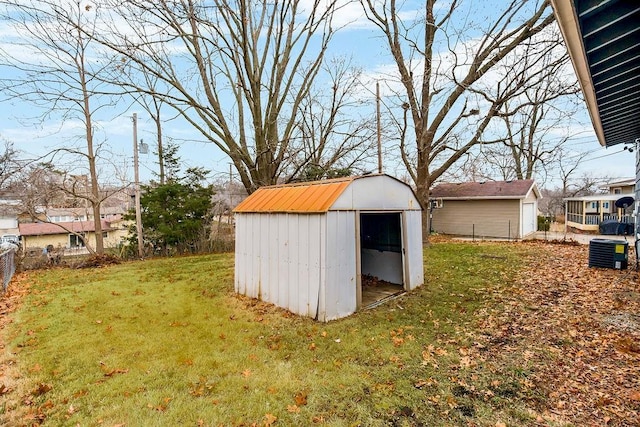 view of outdoor structure with a lawn and central air condition unit