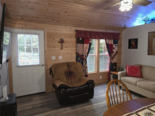 living room featuring ceiling fan, dark wood-type flooring, lofted ceiling, wooden walls, and wood ceiling