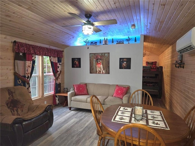 dining space with wood walls, ceiling fan, a wall mounted AC, wood-type flooring, and wood ceiling