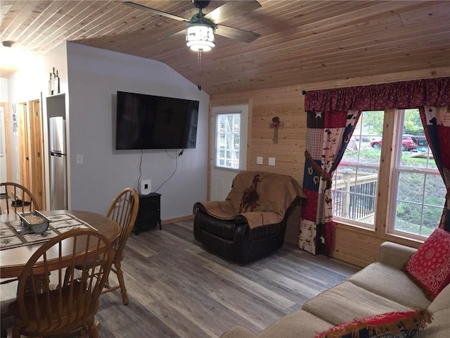 living room with wood walls, ceiling fan, wood ceiling, and vaulted ceiling