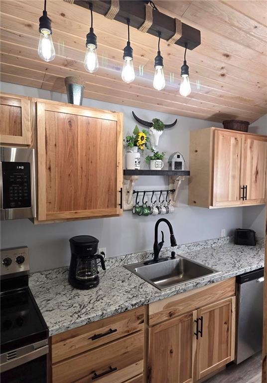 kitchen with pendant lighting, wooden ceiling, sink, light stone counters, and stainless steel appliances