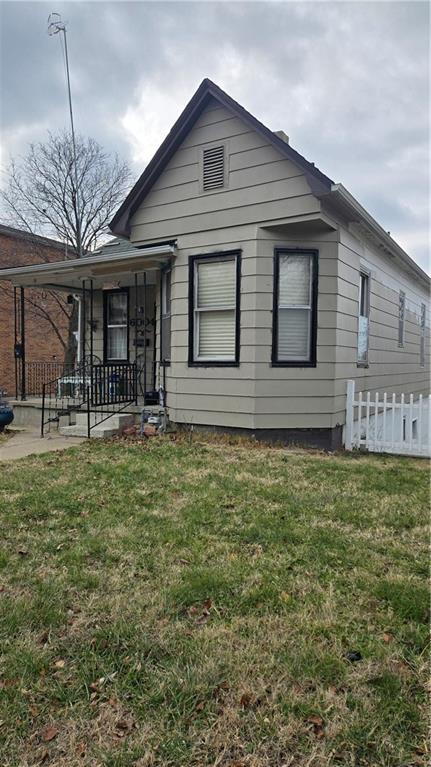 view of front of house with covered porch and a front lawn