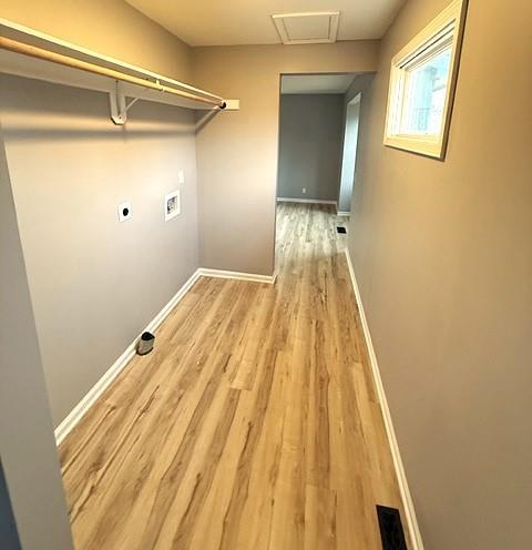 washroom with hookup for an electric dryer, light hardwood / wood-style floors, and washer hookup