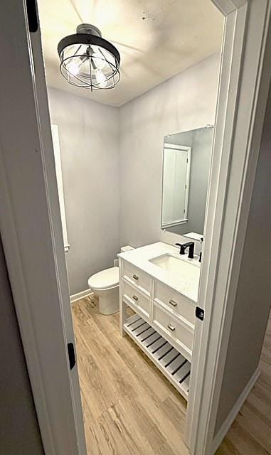 bathroom featuring vanity, wood-type flooring, and toilet