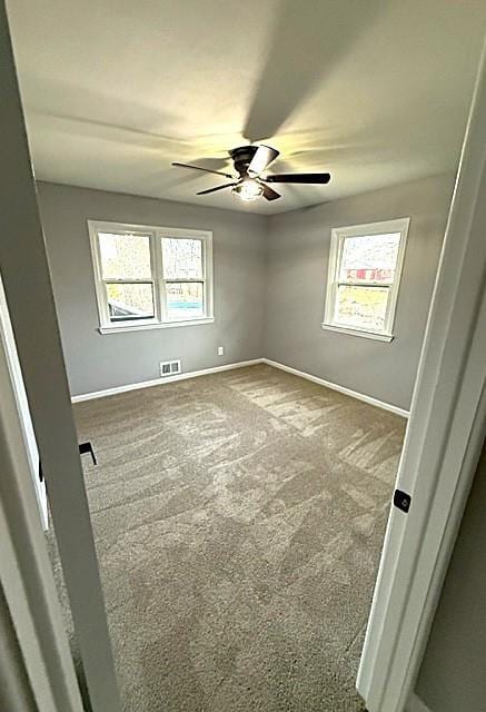 carpeted spare room featuring ceiling fan