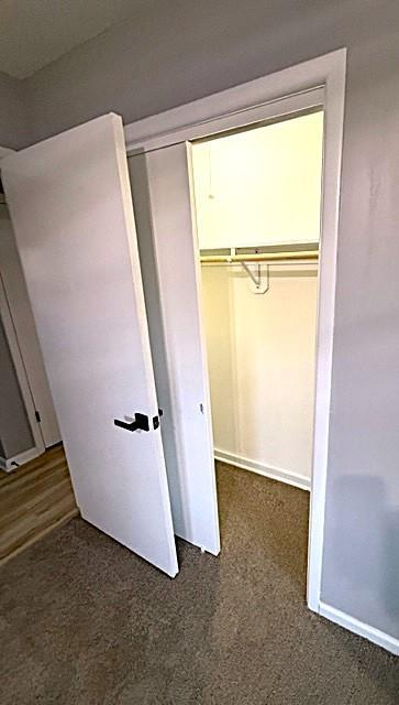 unfurnished bedroom featuring a closet and dark colored carpet