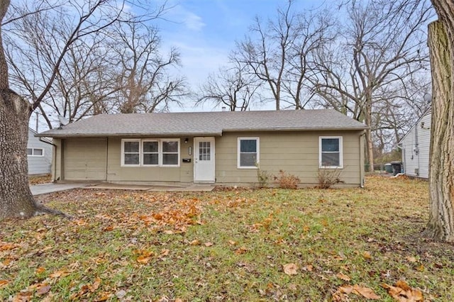 ranch-style house with a garage and a front lawn