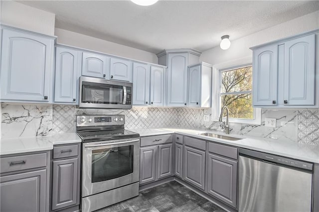 kitchen featuring appliances with stainless steel finishes, tasteful backsplash, and sink