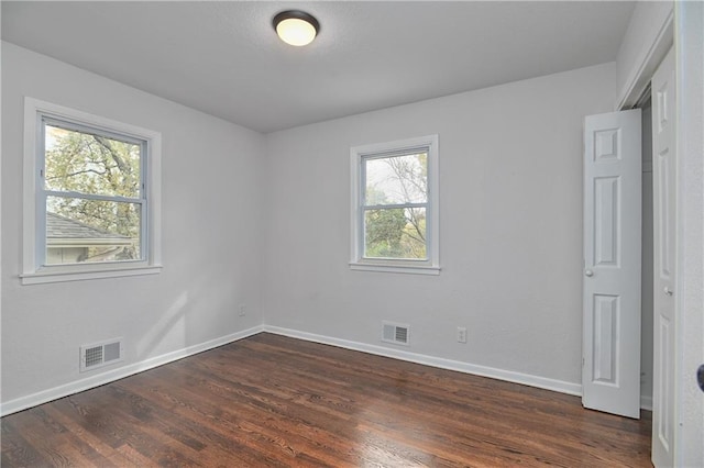 unfurnished room with dark hardwood / wood-style floors