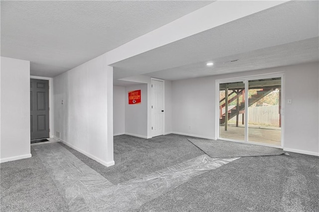 carpeted empty room featuring a textured ceiling