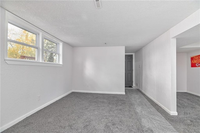 carpeted empty room featuring a textured ceiling