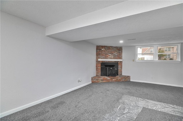 unfurnished living room with a wood stove, carpet floors, and a textured ceiling