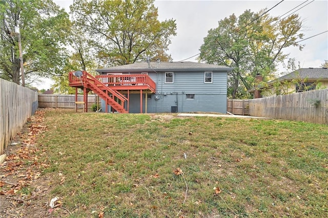 rear view of property featuring a lawn and a deck