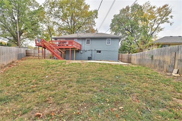 rear view of property featuring a lawn and a deck