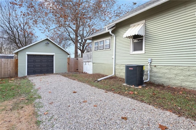 view of property exterior featuring central AC, an outbuilding, and a garage