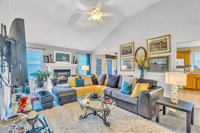 living room with ceiling fan, light hardwood / wood-style flooring, and lofted ceiling