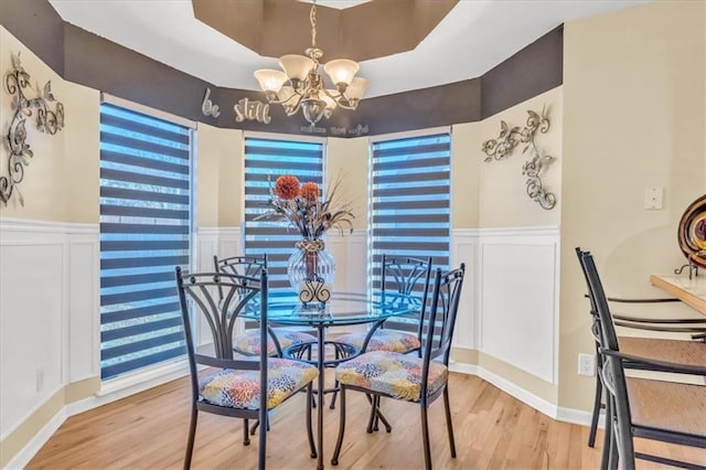 dining space with hardwood / wood-style flooring and an inviting chandelier