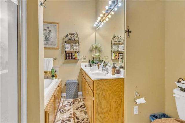 bathroom with toilet, vanity, tile patterned floors, and tiled tub