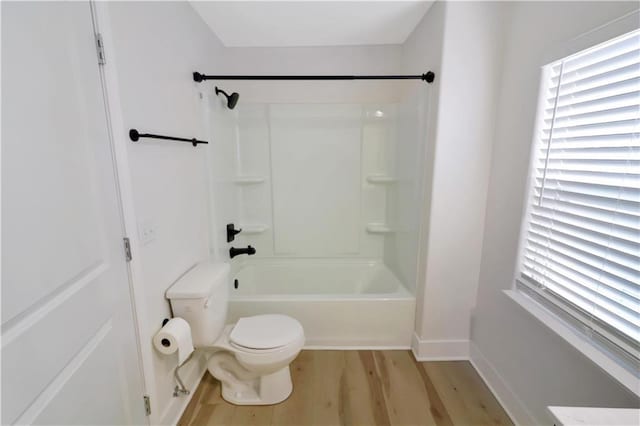 full bath featuring toilet, baseboards, tub / shower combination, and wood finished floors