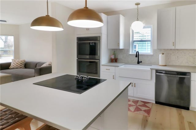 kitchen with stainless steel appliances, tasteful backsplash, a kitchen island, and a sink