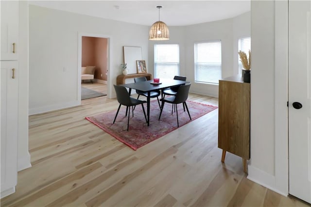 dining room with light wood-style floors and baseboards