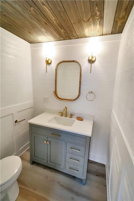 bathroom featuring toilet, wooden ceiling, and vanity