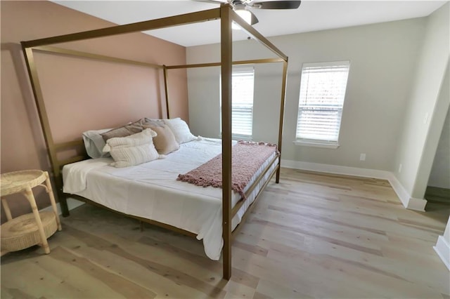 bedroom featuring a ceiling fan, light wood-type flooring, and baseboards