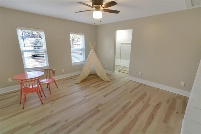 playroom with light wood finished floors, baseboards, and a ceiling fan