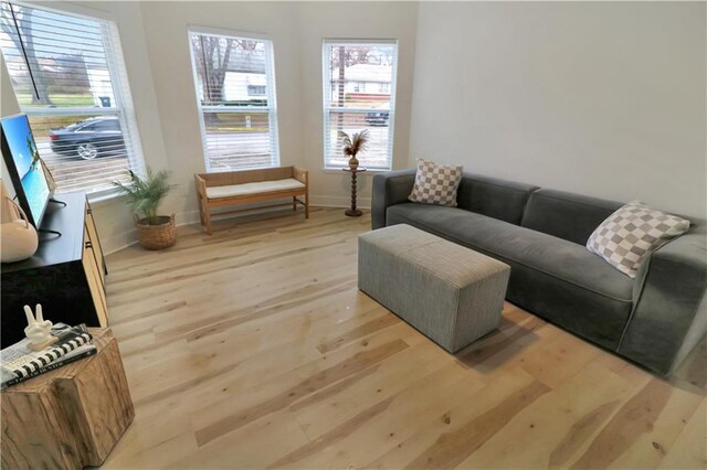 living area with light wood-style flooring and baseboards