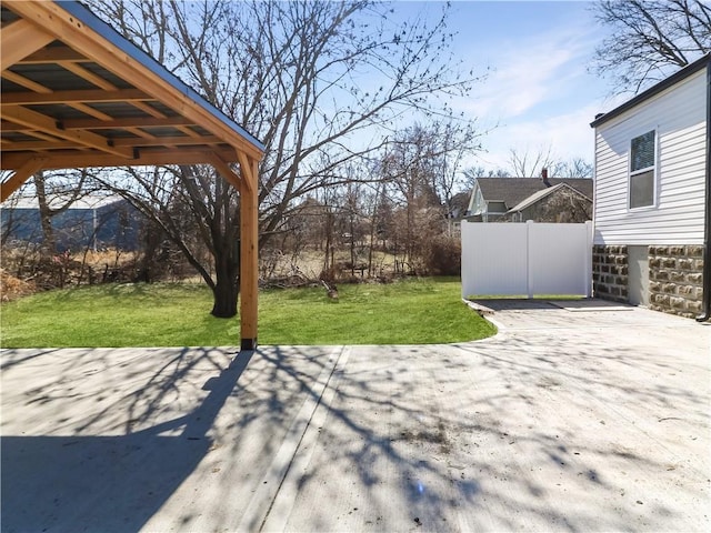 view of yard featuring driveway, a patio, and fence