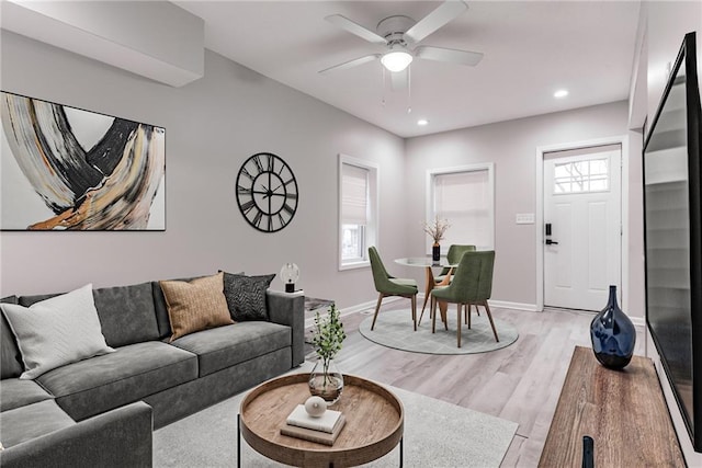 living room featuring ceiling fan and light hardwood / wood-style floors