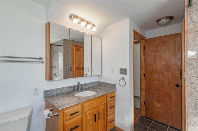 bathroom featuring vanity, toilet, and tile patterned flooring