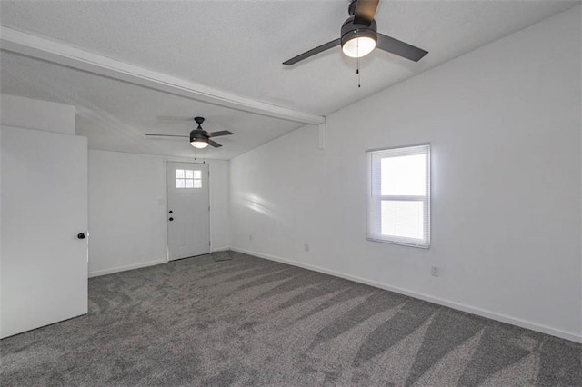 empty room with ceiling fan, carpet flooring, and lofted ceiling with beams