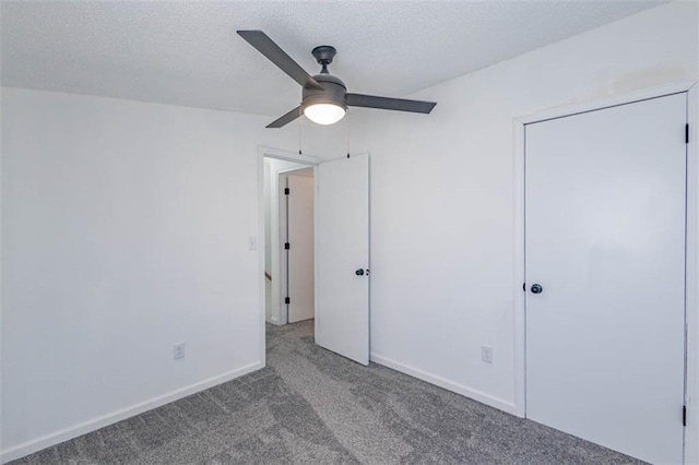 unfurnished bedroom featuring ceiling fan, light colored carpet, and a textured ceiling