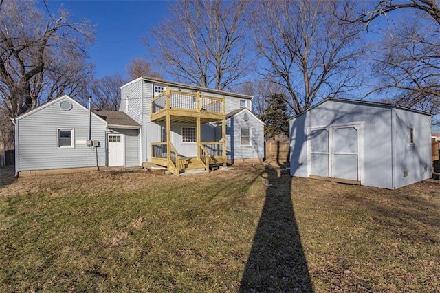 rear view of property with a balcony, a storage shed, and a yard