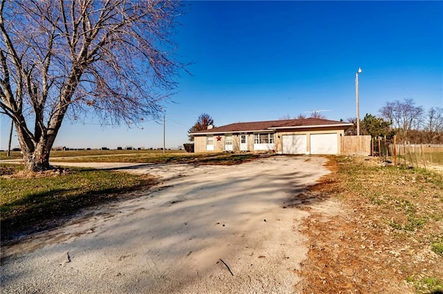 ranch-style house featuring a rural view and a garage